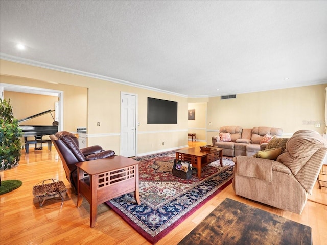 living room with a textured ceiling, hardwood / wood-style flooring, and crown molding