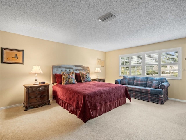 bedroom featuring light carpet and a textured ceiling