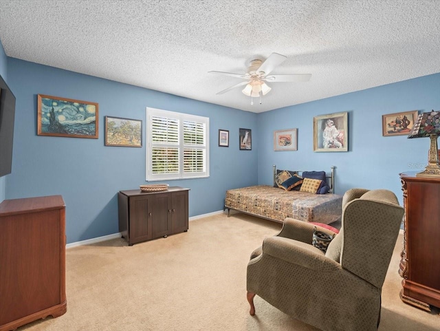 bedroom featuring ceiling fan, light colored carpet, and a textured ceiling