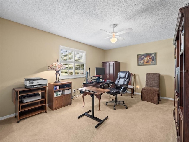 home office featuring light carpet, a textured ceiling, and ceiling fan