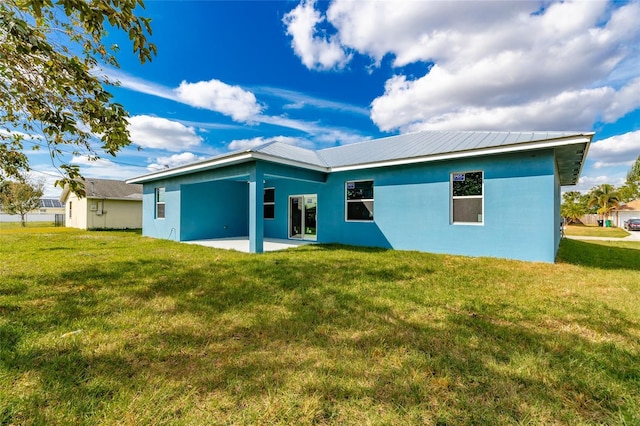 back of property featuring a patio area and a lawn