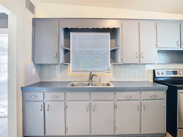 kitchen with electric stove, open shelves, visible vents, decorative backsplash, and a sink