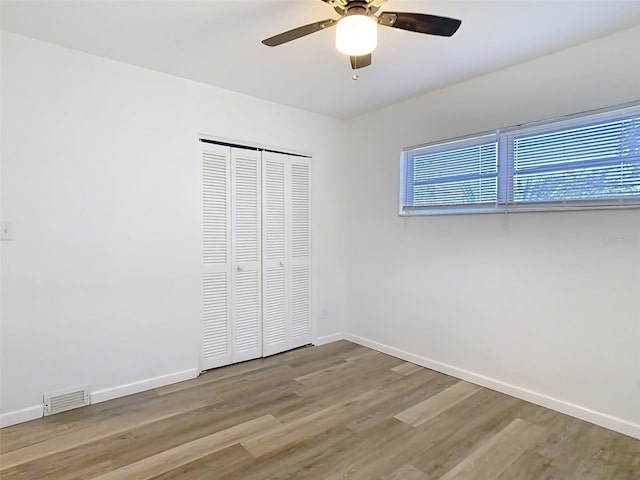 unfurnished bedroom featuring visible vents, baseboards, and wood finished floors