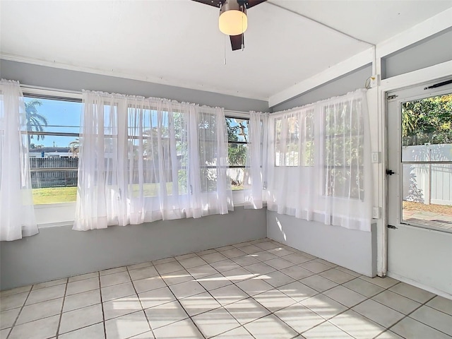 unfurnished sunroom featuring vaulted ceiling, plenty of natural light, and a ceiling fan