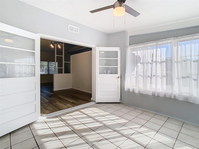 spare room featuring ceiling fan, visible vents, and tile patterned floors