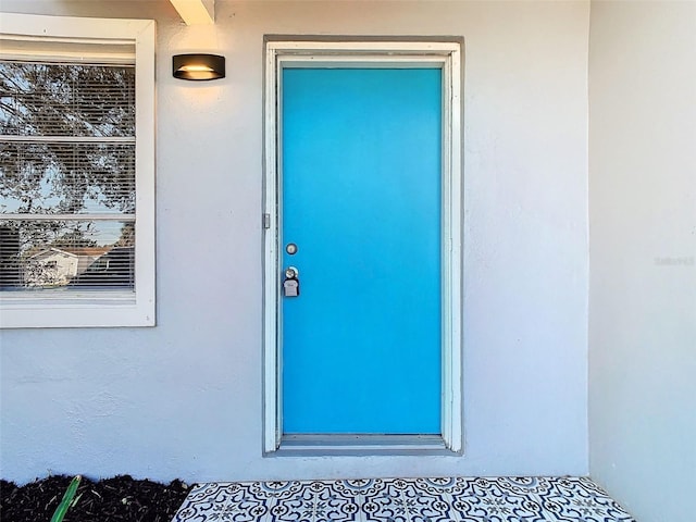 view of exterior entry with stucco siding