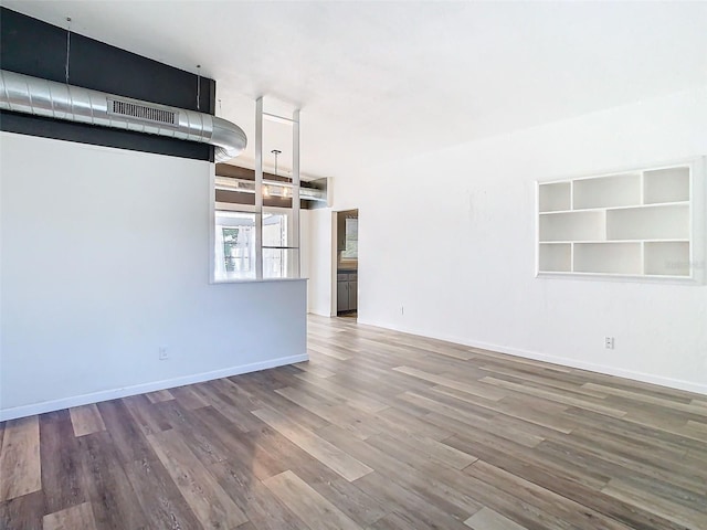 unfurnished living room with baseboards and wood finished floors