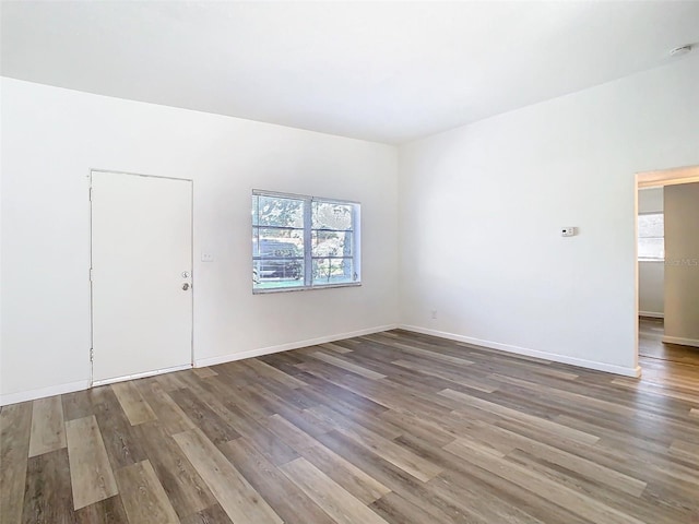 spare room featuring wood finished floors and baseboards