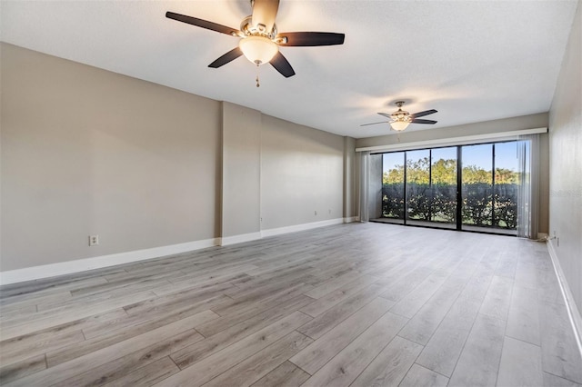 spare room featuring ceiling fan, light wood-type flooring, and a textured ceiling