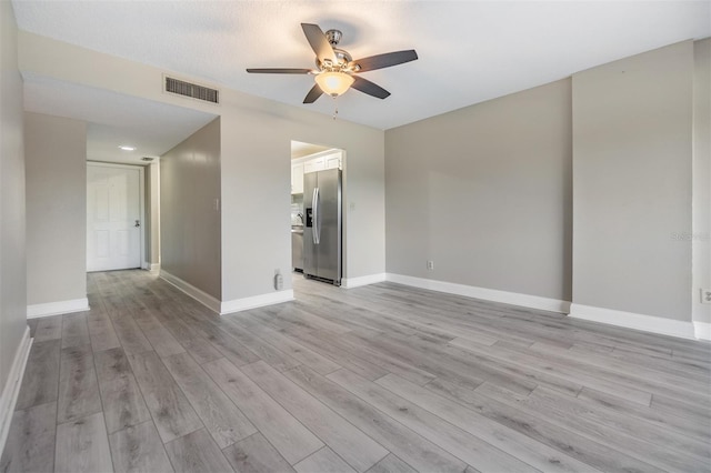 unfurnished living room featuring ceiling fan, light hardwood / wood-style floors, and a textured ceiling