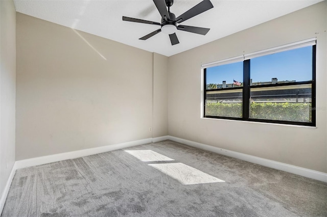 carpeted spare room featuring ceiling fan