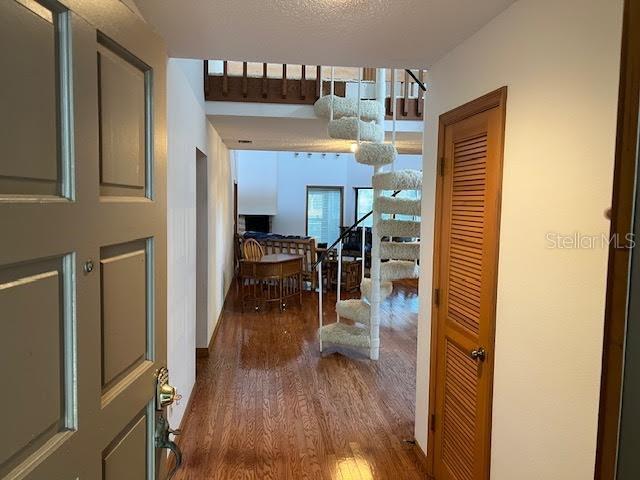 hallway with a textured ceiling and hardwood / wood-style flooring