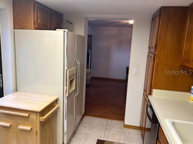 kitchen with dishwasher, white fridge with ice dispenser, and sink