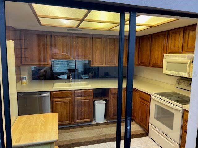 kitchen with wood counters, white appliances, and sink