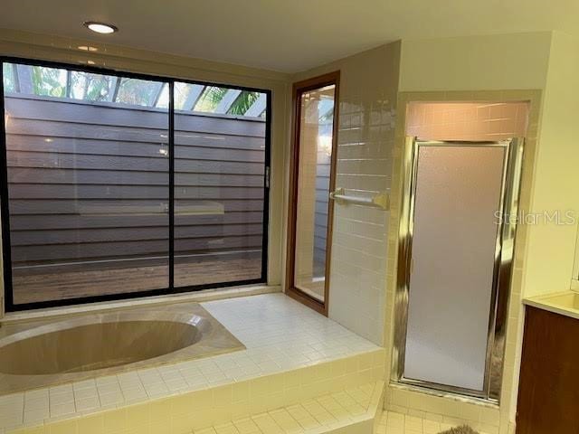 bathroom featuring tile patterned flooring, vanity, and independent shower and bath