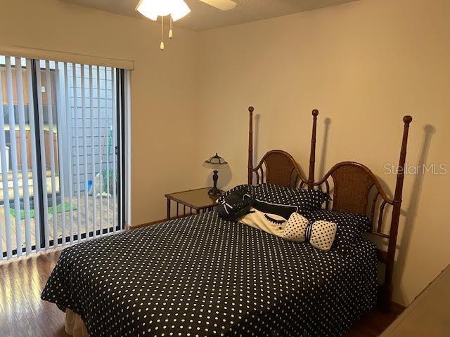 bedroom featuring multiple windows, hardwood / wood-style flooring, and ceiling fan