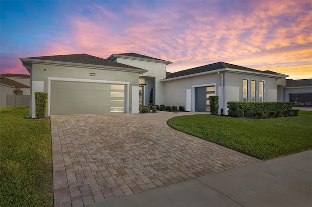 view of front of home with a garage and a yard