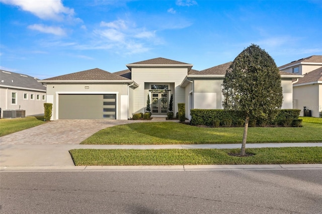 view of front of house featuring a front lawn, a garage, and french doors