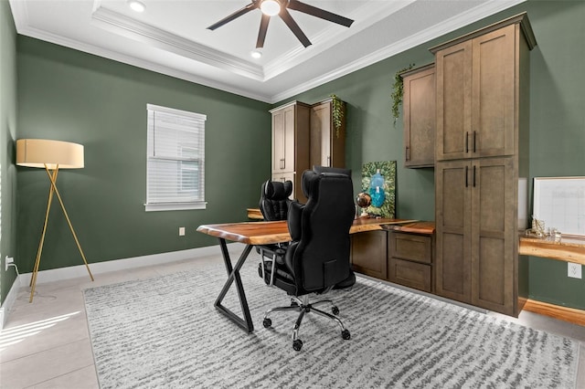 office area featuring a raised ceiling, ornamental molding, light tile patterned flooring, and ceiling fan