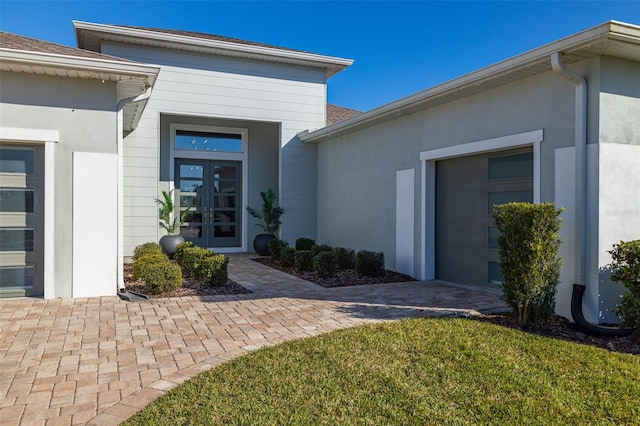 entrance to property with a yard and french doors