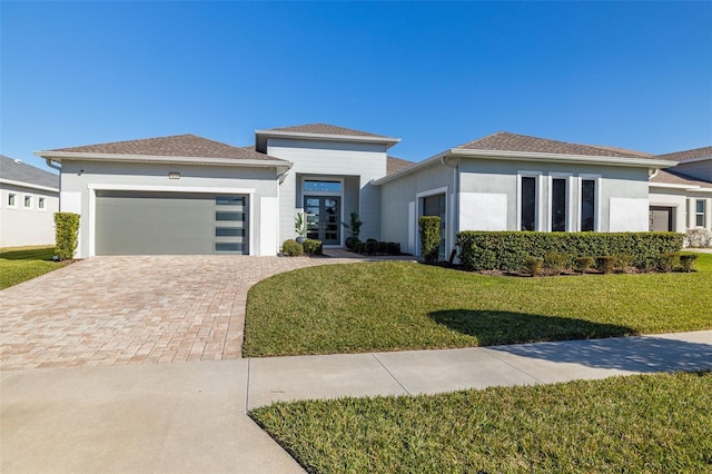 prairie-style home with a garage and a front lawn