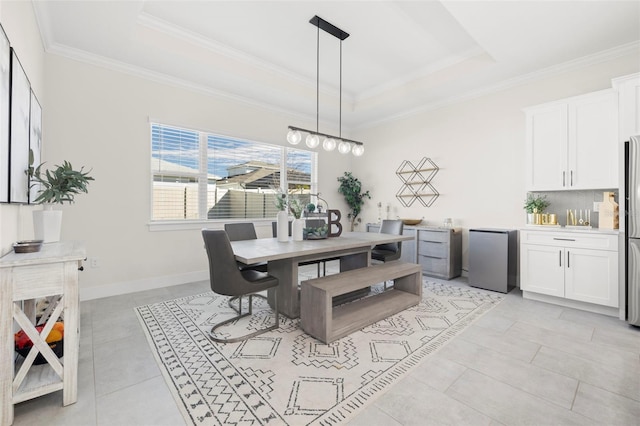 dining room featuring crown molding, light tile patterned floors, and a tray ceiling