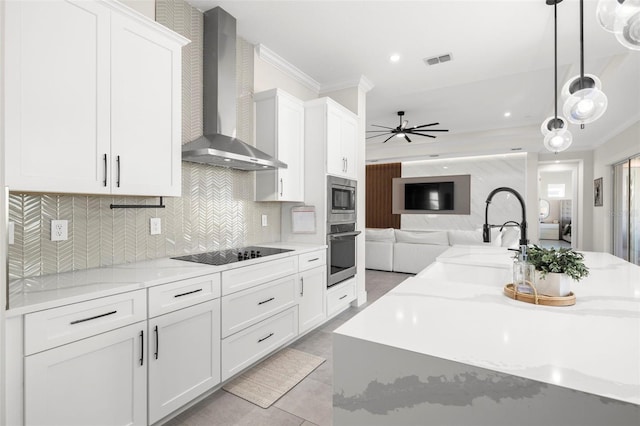 kitchen with wall chimney exhaust hood, stainless steel appliances, and white cabinets