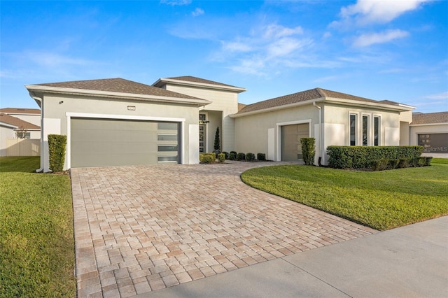 prairie-style home featuring a garage and a front lawn