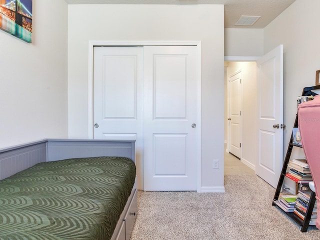 bedroom with a closet and light carpet