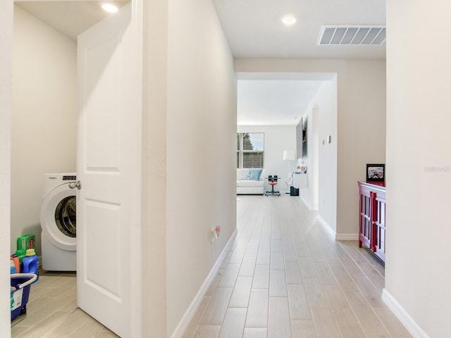 corridor featuring light hardwood / wood-style floors and washer / dryer