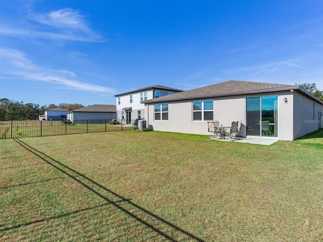 back of property with a lawn and a patio area