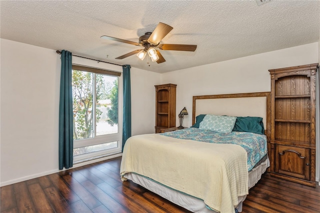 bedroom with ceiling fan, dark hardwood / wood-style floors, and a textured ceiling