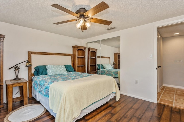 bedroom featuring ceiling fan, a textured ceiling, a closet, and dark hardwood / wood-style flooring