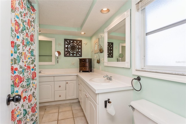 bathroom featuring toilet, a wealth of natural light, tile patterned flooring, and vanity