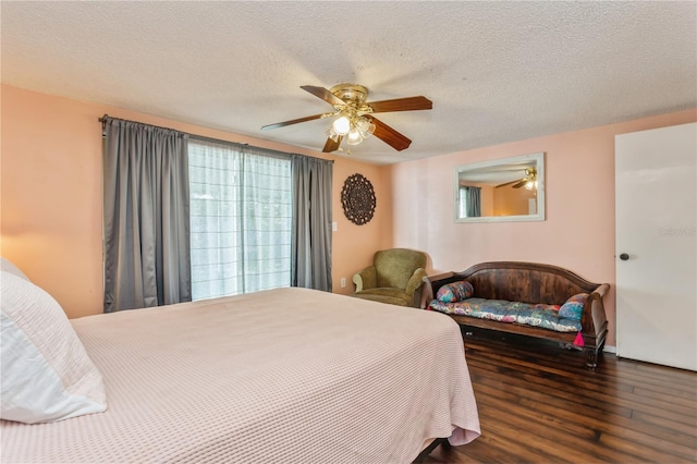 bedroom with a textured ceiling, ceiling fan, and dark hardwood / wood-style floors