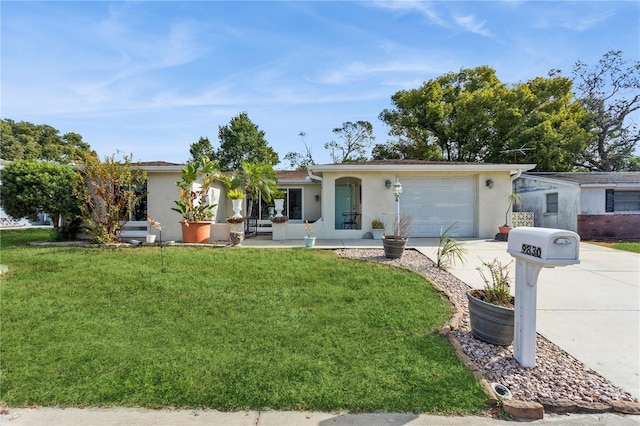 single story home with a front lawn, a garage, and covered porch