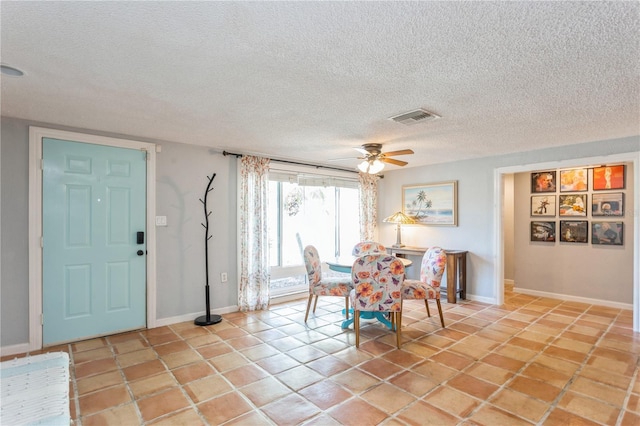 tiled dining area featuring a textured ceiling and ceiling fan