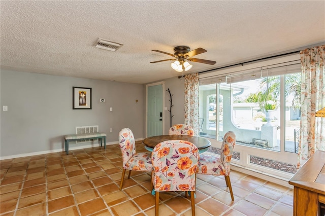 dining space featuring a textured ceiling, ceiling fan, and tile patterned flooring