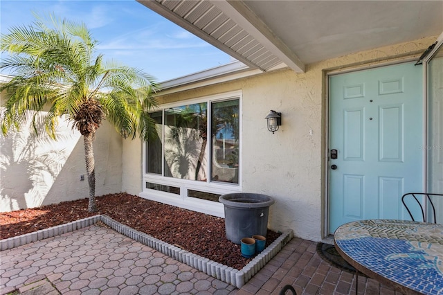 doorway to property with a patio area and stucco siding