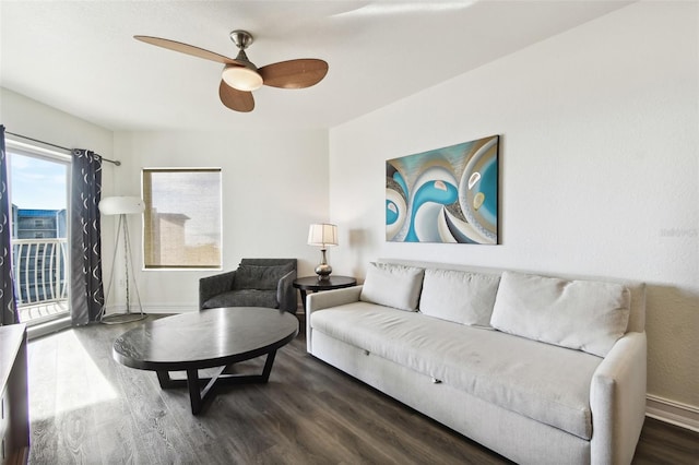 living room featuring ceiling fan and dark wood-type flooring