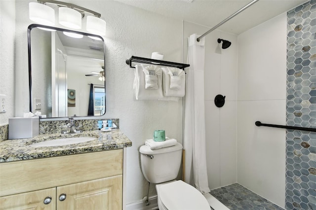 bathroom with ceiling fan, a textured ceiling, toilet, vanity, and a shower with shower curtain