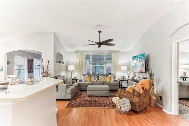 living room featuring ceiling fan, light wood-type flooring, and lofted ceiling