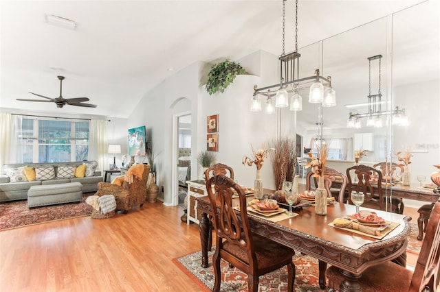 dining room featuring ceiling fan, lofted ceiling, and light hardwood / wood-style flooring