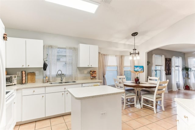 kitchen featuring pendant lighting, white cabinetry, a kitchen island, and sink