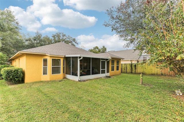 rear view of house with a yard and a sunroom