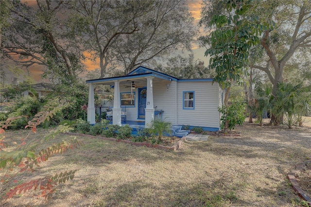 view of front of property with a lawn, ceiling fan, and covered porch