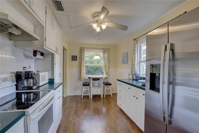 kitchen with white cabinetry, ceiling fan, dark hardwood / wood-style flooring, backsplash, and white appliances