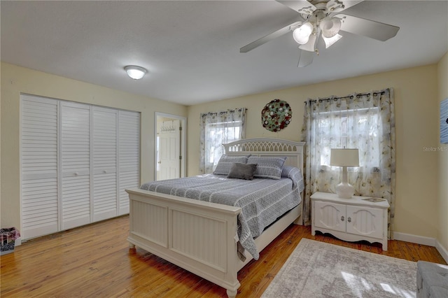 bedroom with ceiling fan, a closet, and light hardwood / wood-style flooring