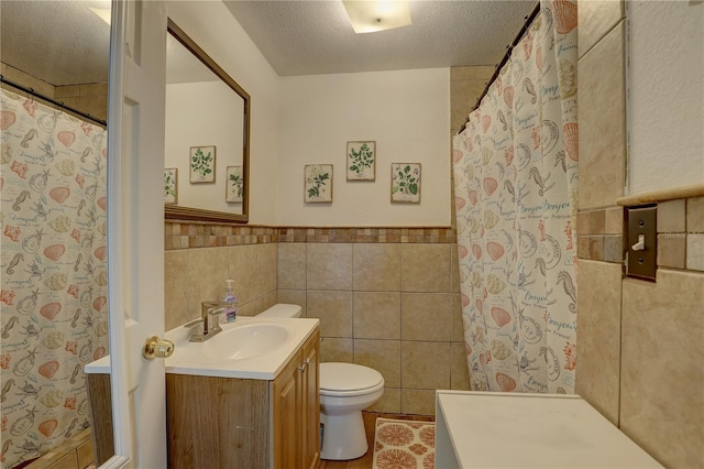 bathroom featuring curtained shower, a textured ceiling, toilet, vanity, and tile walls