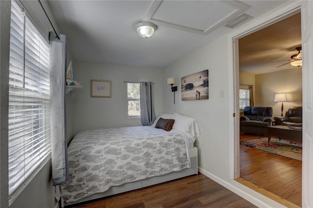 bedroom featuring multiple windows, ceiling fan, and dark wood-type flooring